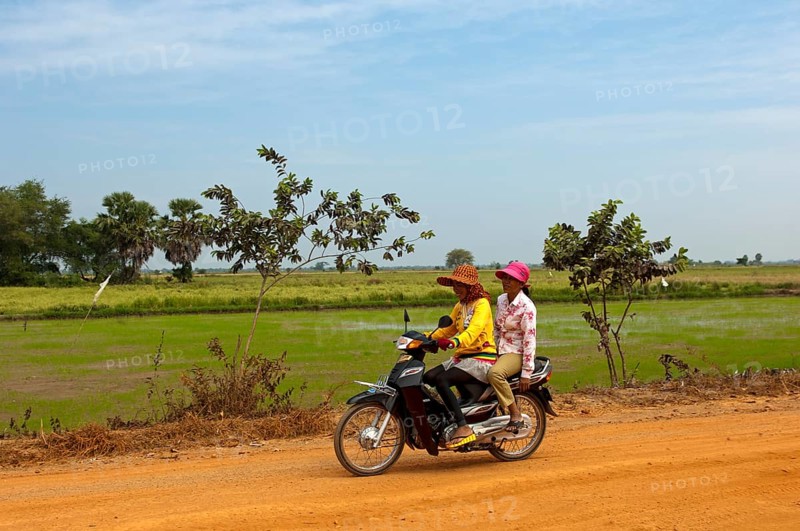 Two women riding on a motorcycle on a country road