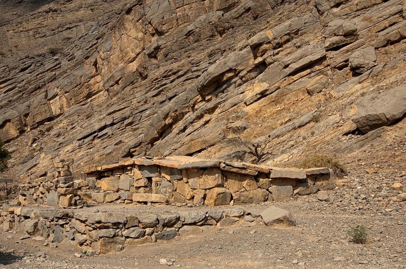 Bedouin stone house matching in colour and texture to the foot of a cliff in the mountains of Musandam