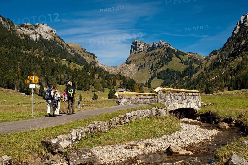 Hikers at Groenbach stream in front of the summit of Schibe Mountain