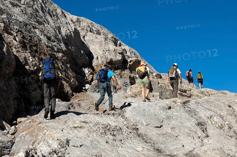 Hikers crossing the exposed bedrock of Tsanfleuron Glacier