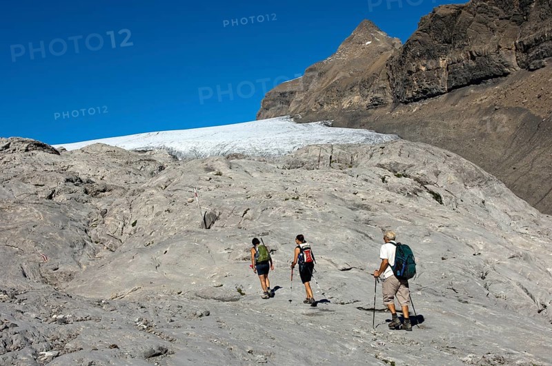 Hikers crossing the exposed bedrock of Tsanfleuron Glacier