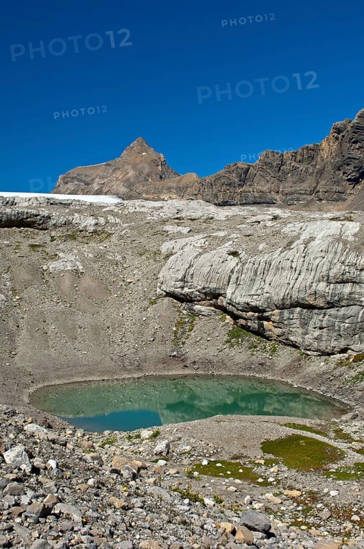 Lake of green meltwater in a doline or sinkhole in the end moraine of Tsanfleuron Glacier at Sanetsch Pass