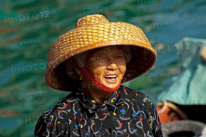 Laughing old Chinese fishmonger with straw hat