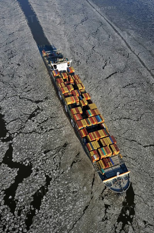 Container ship on the Elbe River with ice flow