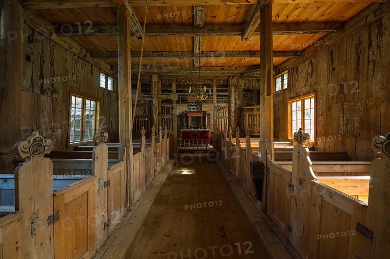 Stave church interior with pews and an altar