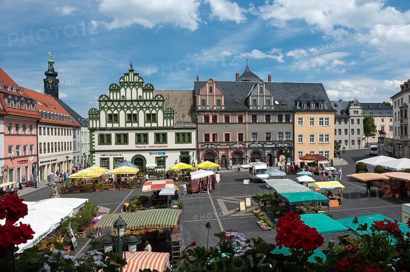 Weekly market on the market square in front of Lucas Cranach house and a town house with half-timbered gables