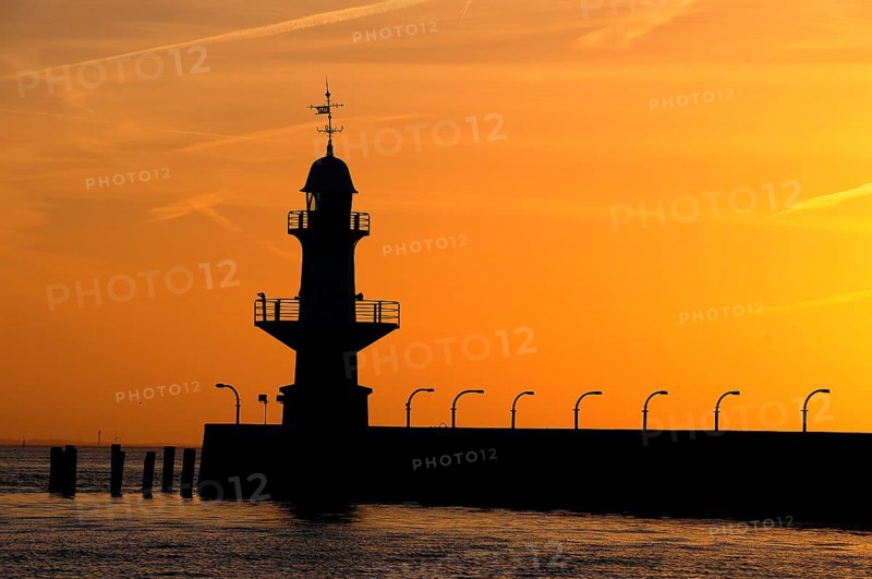 Silhouette of the Brunsbuttel Mole 1 lighthouse in front of a evening sky