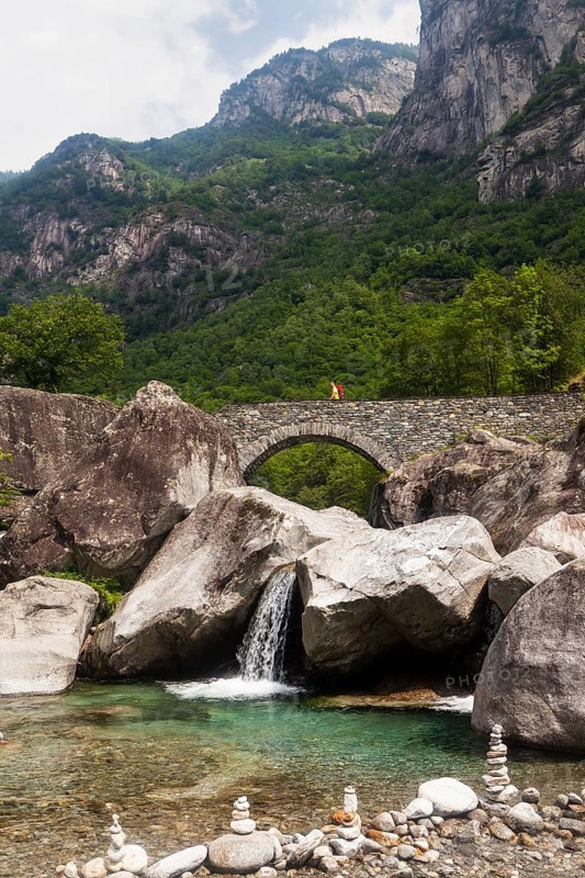 Medieval bridge with hikers near Fontana