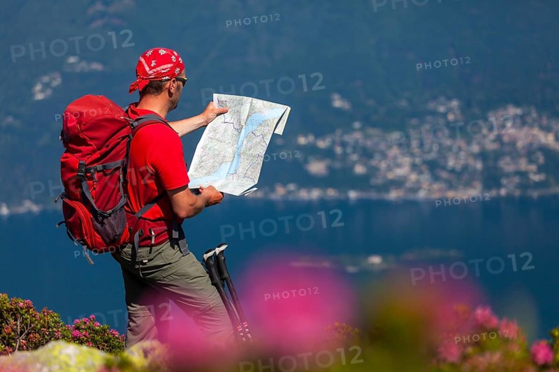 Man studying the trail map while hiking on Monte Covreto