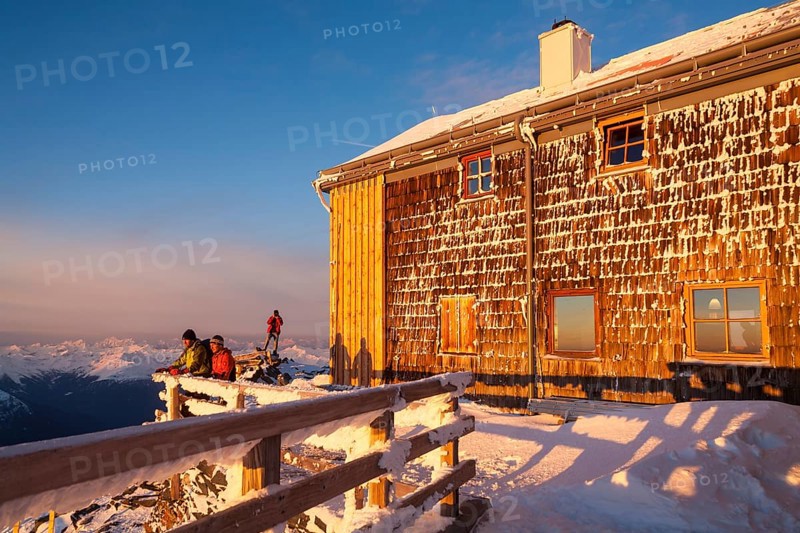 Two mountaineers watching the sunrise at the Archduke Johann cabin on Mt Grossglockner