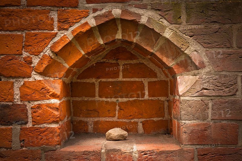 Stone in the niche of a brick wall