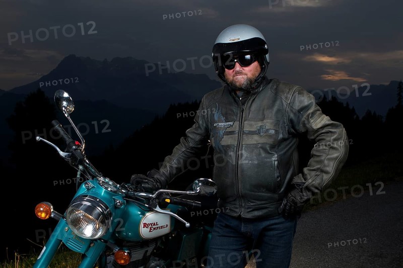 Motorcycle rider standing next to his motorbike