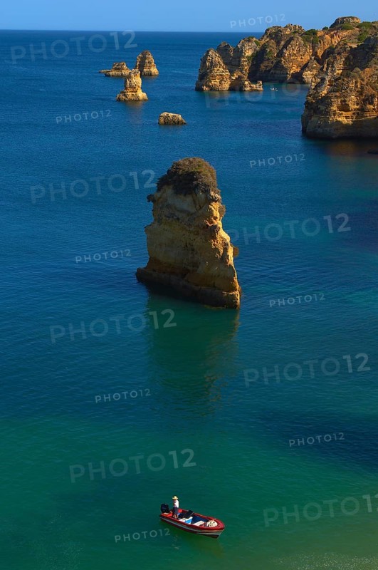 Boat off the cliffs at Praia da Dona Ana beach