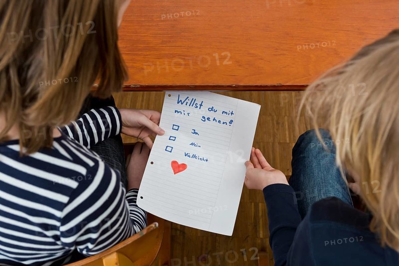 School children secretly passing notes under the school desk