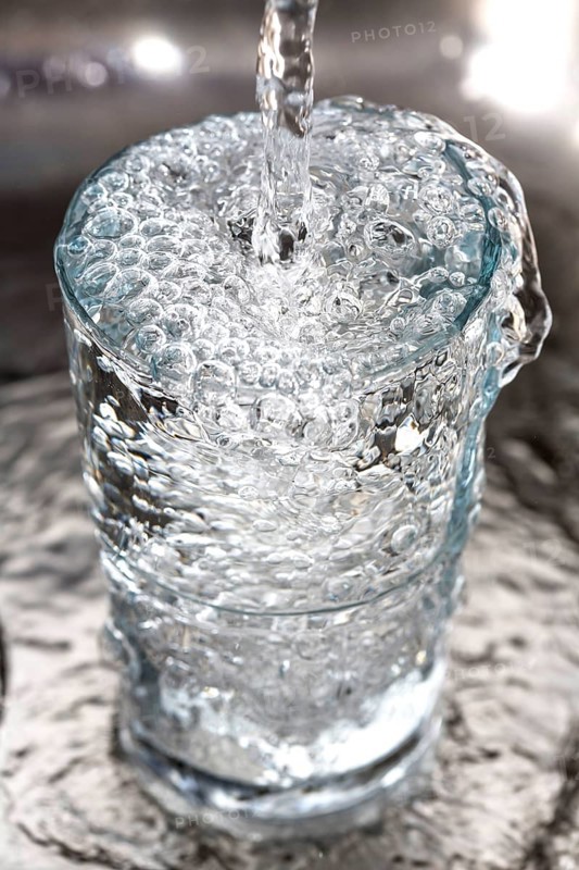 Water overflowing in a glass