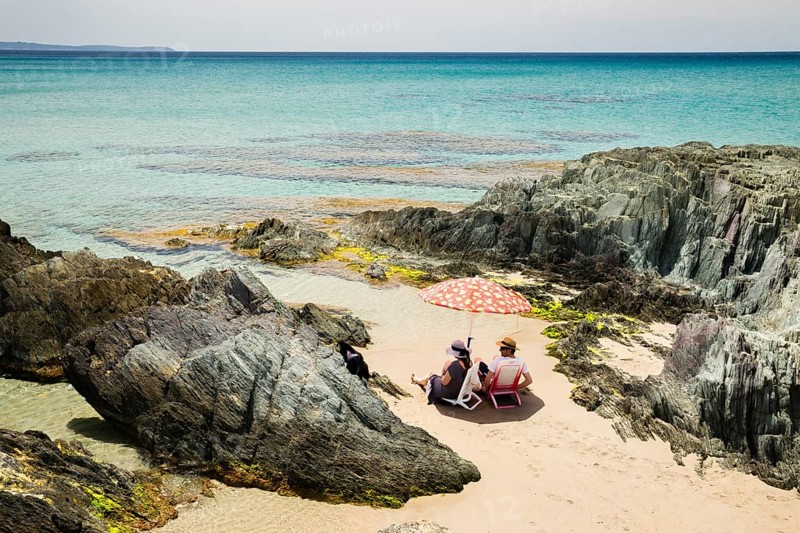 Couple sitting on the beach of Masua