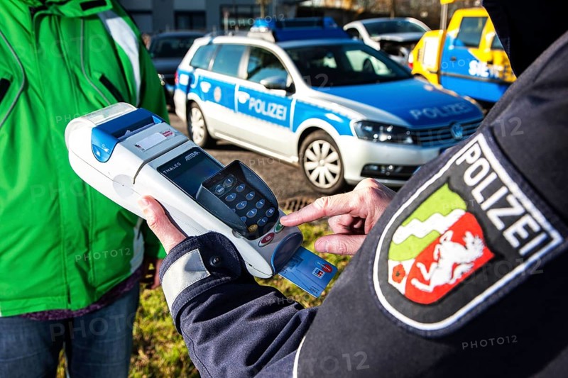 Police officer collecting an on-the-spot fine with a card reader