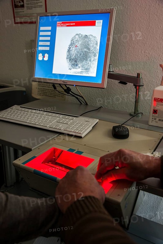 Fingerprints and palm prints of a suspicious person are recorded with a scanner