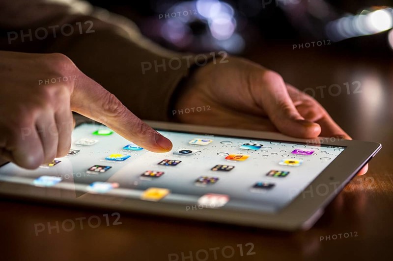 Finger touching the touch screen of an Apple iPad