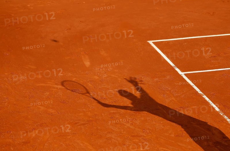 Shadow of a tennis player serving the ball