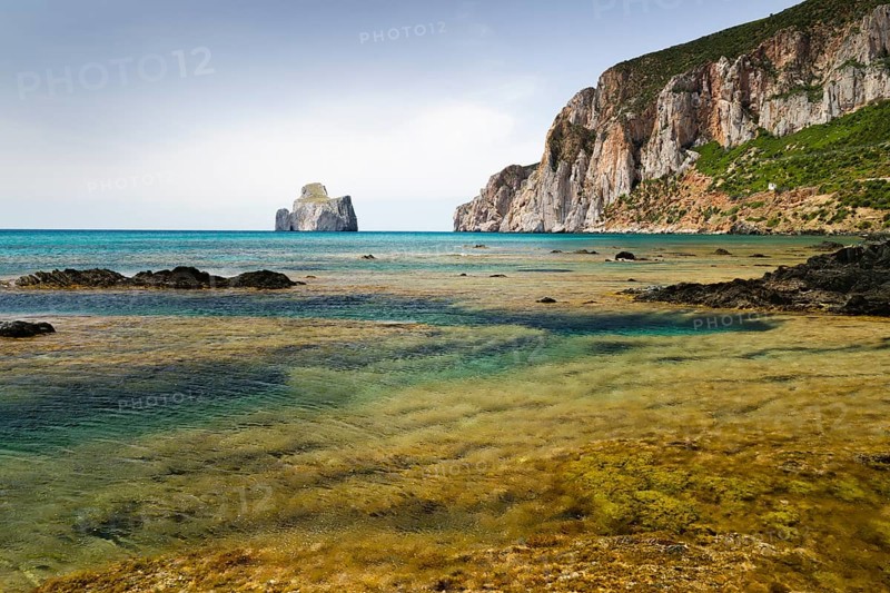 Spiaggia di Masua bay with the Pan di Zuccherof rock island in the sea