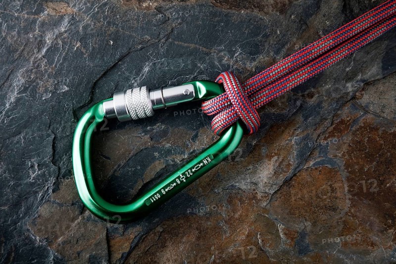 Carabiner with rope on a stone surface