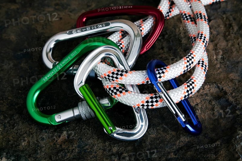 Five carabiner on rope on a stone surface