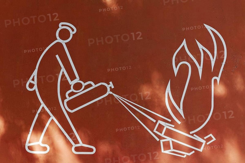 Man putting out a fire with fire extinguishers