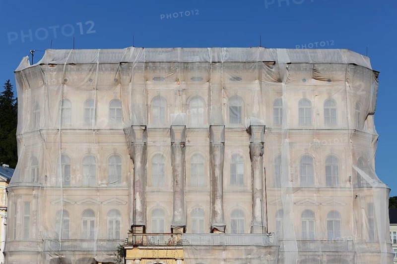 Facade of a historic building shrouded with tarpaulins during renovation