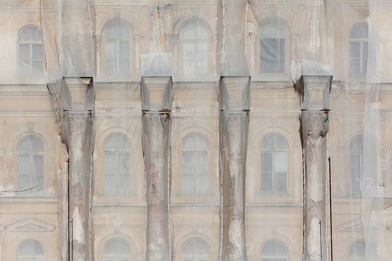 Facade of a historic building shrouded with tarpaulins during renovation