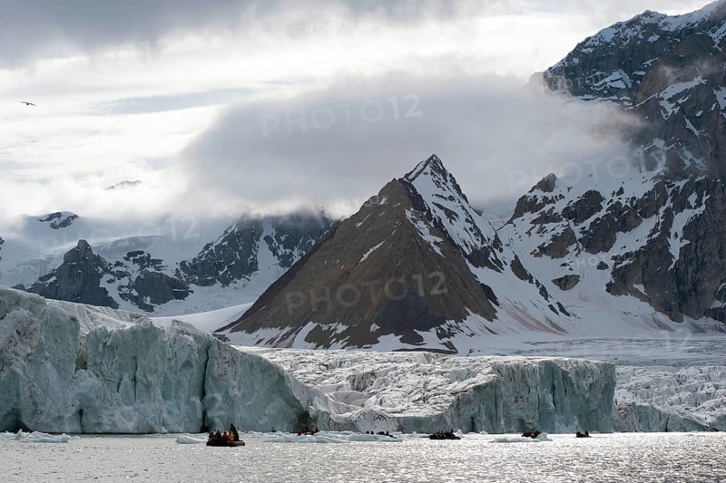 Zodiac inflatable boat during an expedition cruise in front of Samarinbreen Glacier and Tindegga Mountain