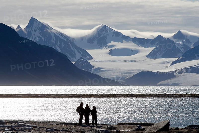 Silhouettes of expedition participants in front of the mountain and glacier scenery of Smeerenburgbreen