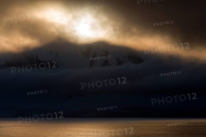 Low-standing sun shining through dense cloud cover