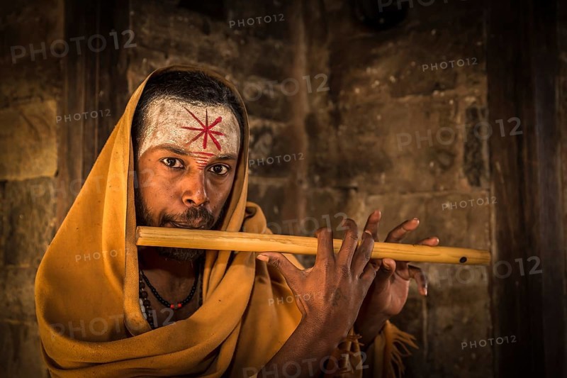 A sadhu playing a flute