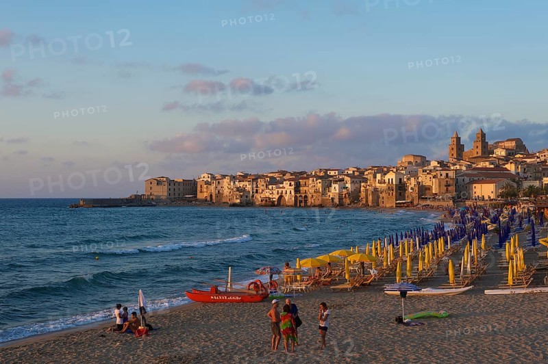Beach and historic town centre with Cathedral of San Salvatore at dusk