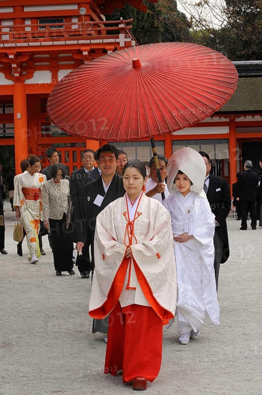 Japanese woman wearing scarlet hakama pants and a white kimono shirt with lengthy sleeves