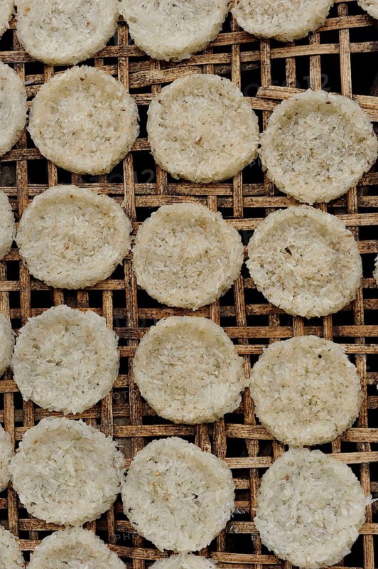 Round rice cakes made of glutinous rice drying on a bamboo frame