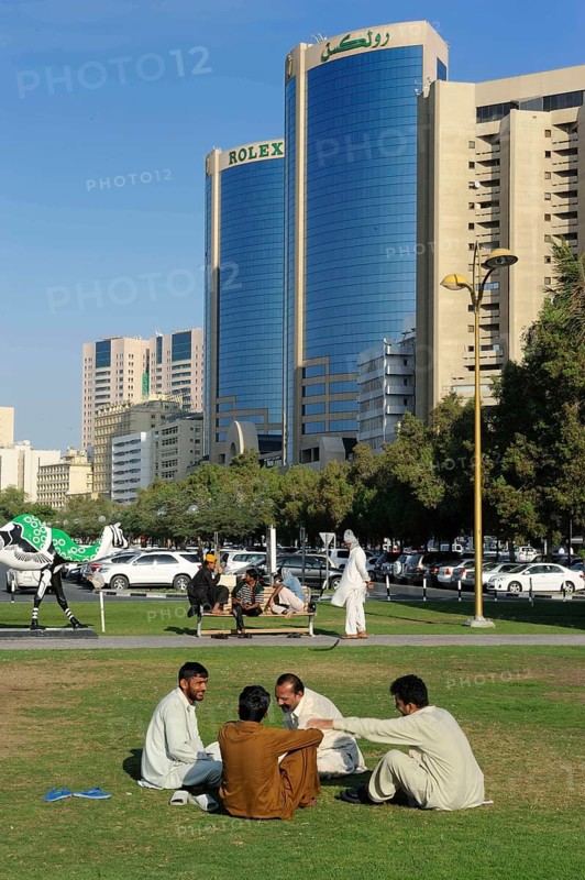 Locals in a park in front of the Rolex Towers