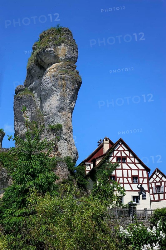 Half-timbered house next to towering karst rocks