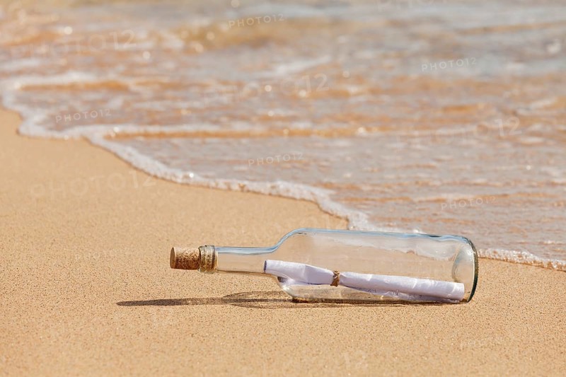 Message in a bottle lying on the beach