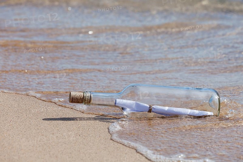 Message in a bottle lying on the beach