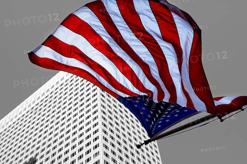 U.S.-American flag flying in front of a skyscraper