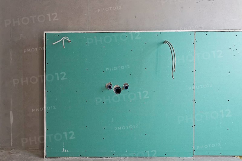 Wall with a cover for the installation of a sink