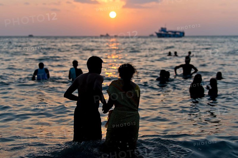Hindu pilgrims taking a holy bath in the sea at sunrise