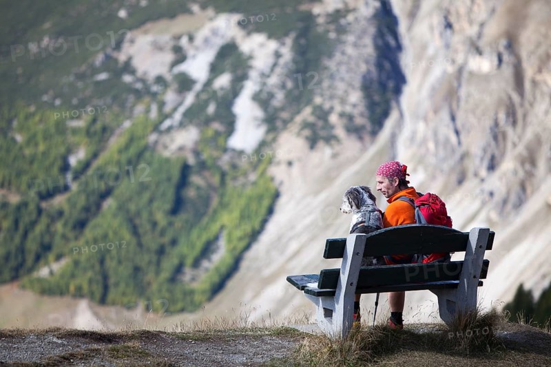 Hiker sitting on a bench next to his dog