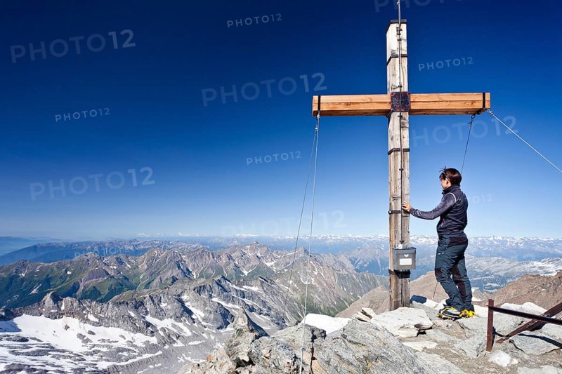 Mountain climber at the summit cross of Hochfeiler Mountain