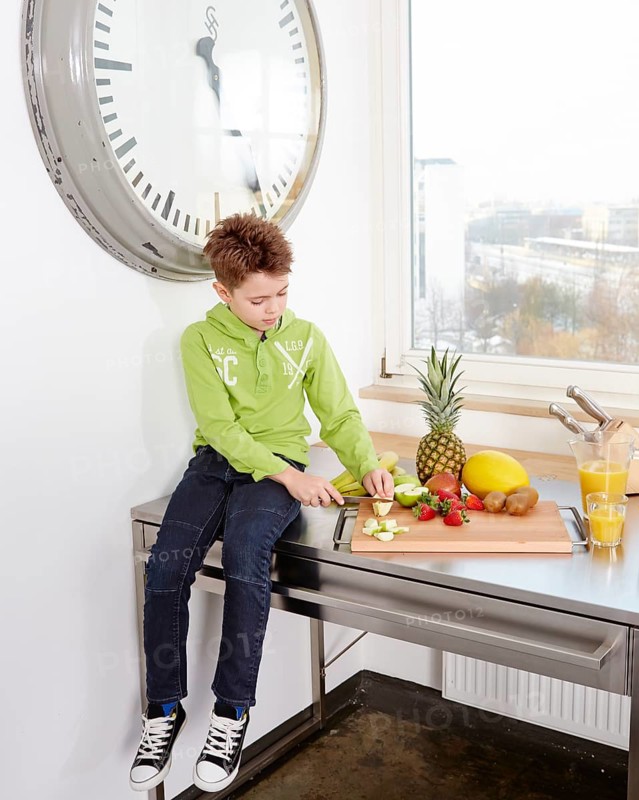 Young boy sitting on a kitchen worktop