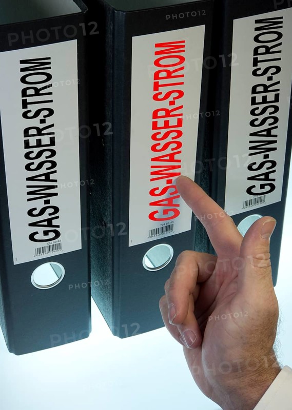 Hand pointing to a ring binder labeled Gas-Wasser-Strom