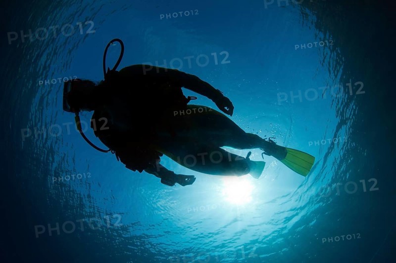 Silhouette of a scuba diver under water