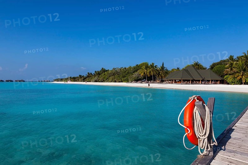 View from a jetty with a life buoy of the beach with a gazebo